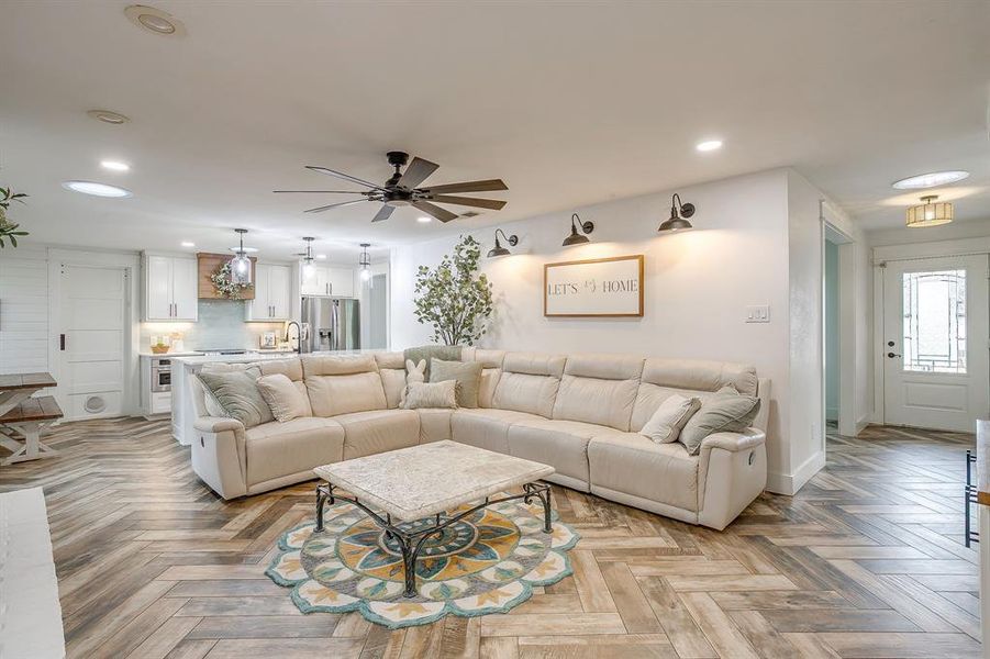 Living room featuring parquet floors, ceiling fan, and recessed lighting