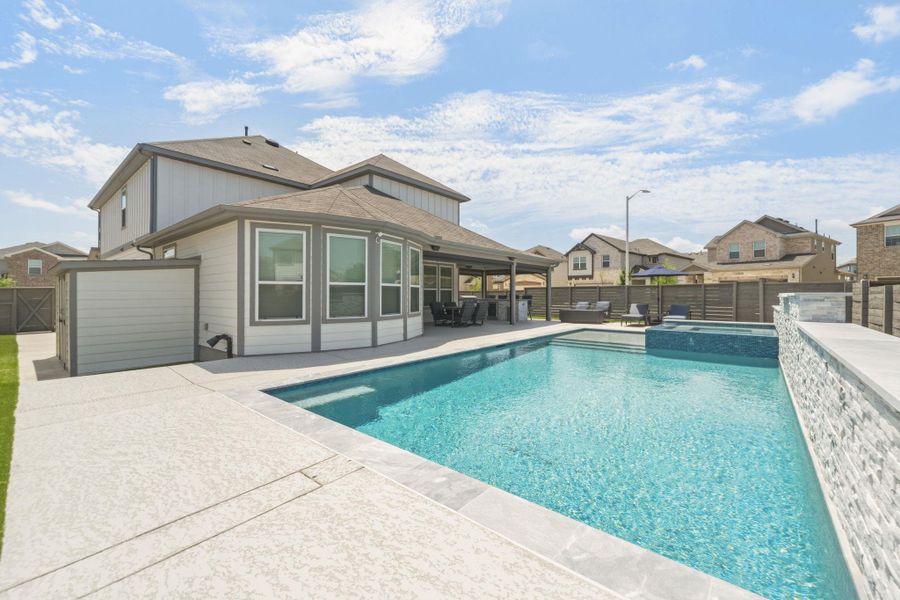 Expansive cool coat concrete patio surrounding a swimming pool with integrated spa