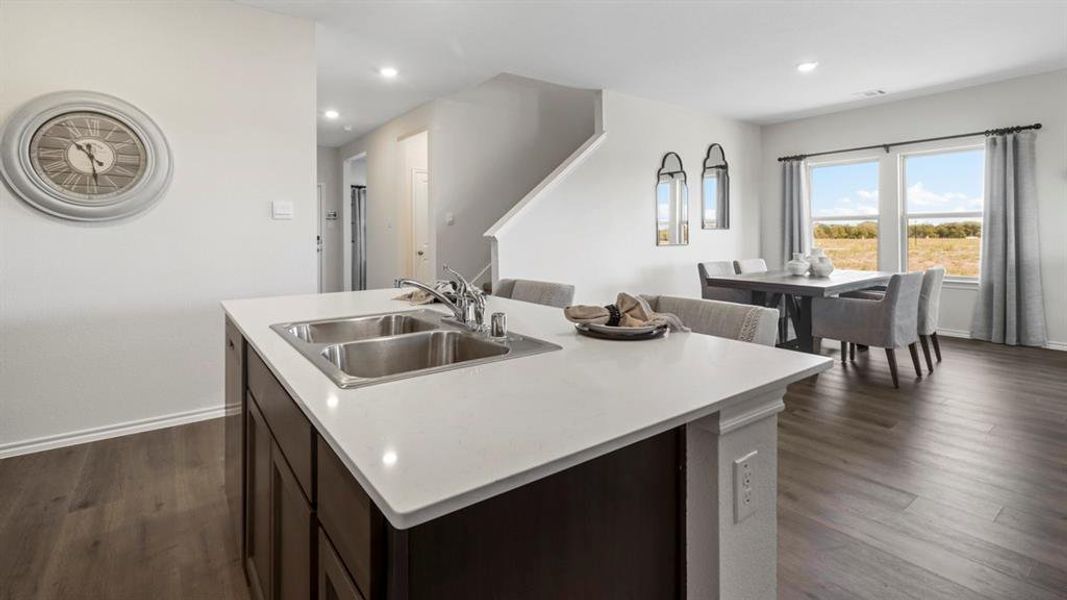 Kitchen featuring dark wood finished floors, recessed lighting, an island with sink, dark brown cabinets, and open floor plan
