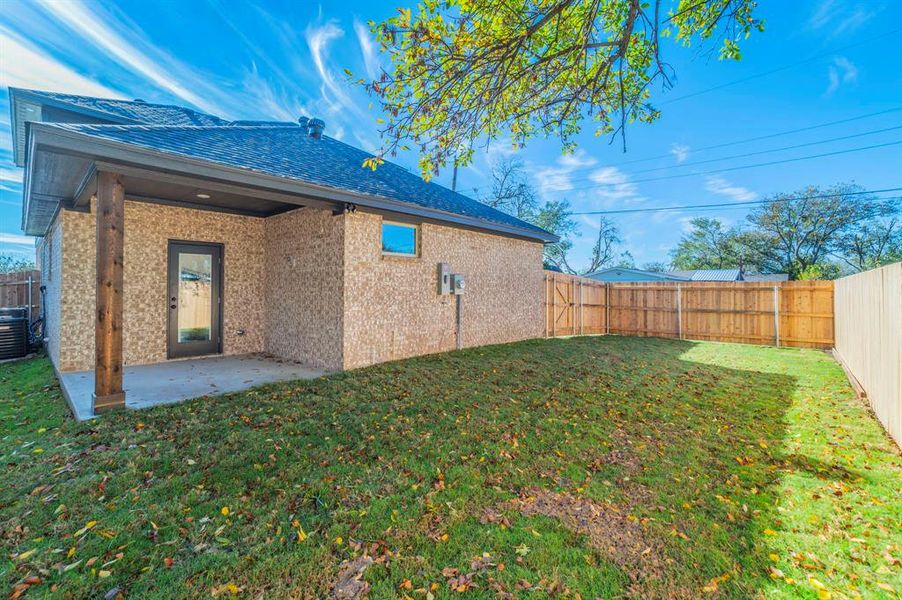 Back of house featuring a patio area, a fenced backyard, brick siding, and roof with shingles Back of house featuring a patio area, a fenced backyard, brick siding, and roof with shingles
