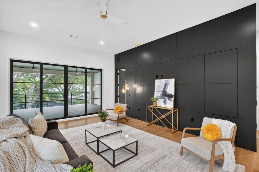 Natural light pours into this living space, featuring elegant hardwood flooring and a ceiling fan for optimal comfort.