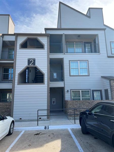 View of building exterior with uncovered parking