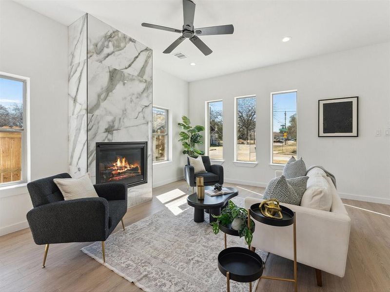 Living area with recessed lighting, visible vents, a premium fireplace, light wood-type flooring, and baseboards