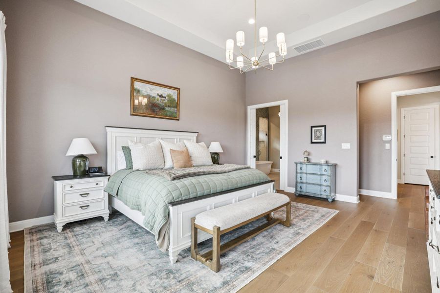 Designed as a personal sanctuary, the primary suite is highlighted by an elegant tray ceiling and large windows that welcome abundant natural light.