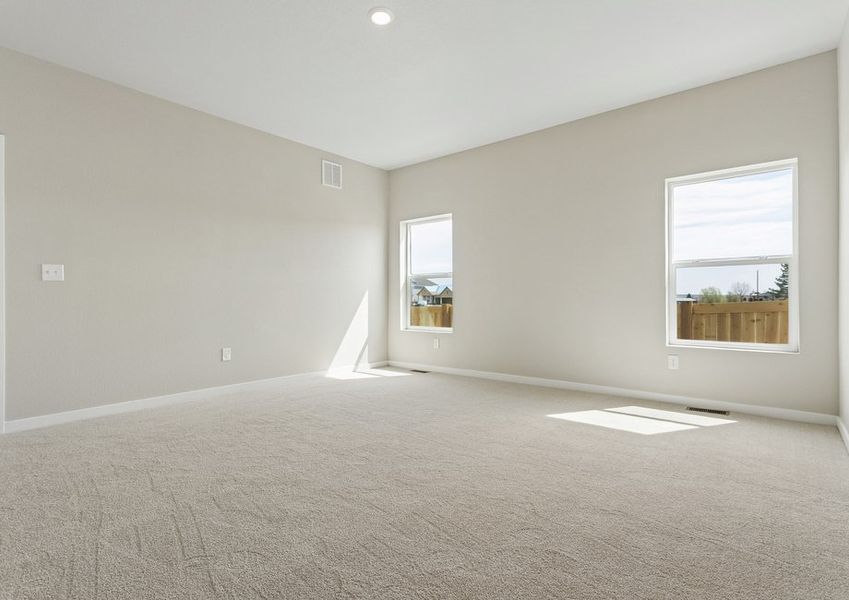 The master bedroom is spacious with large windows.,