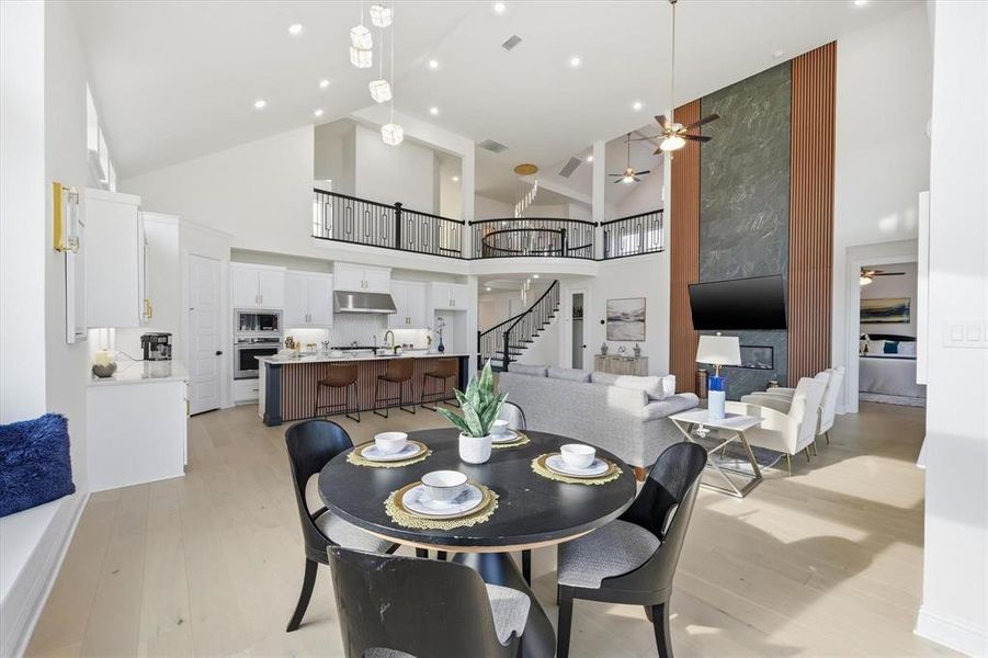 Spacious open-concept interior featuring light wood-finish flooring and high vaulted ceilings