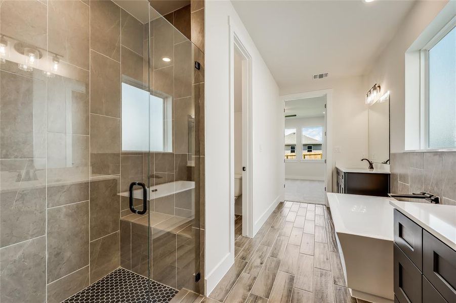 Separate shower and bathtub with complimenting tilework throughout. I love the little seat in the shower!