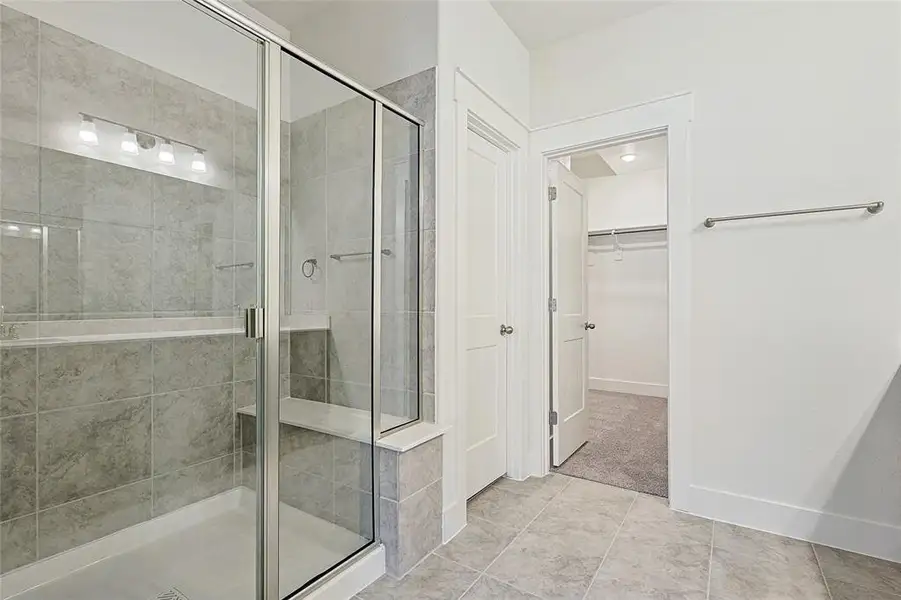 Bathroom with a spacious closet and a shower stall