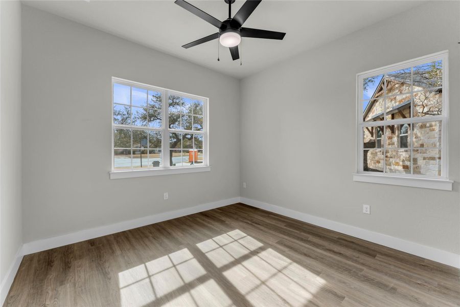 Empty room featuring light wood finished floors and a ceiling fan