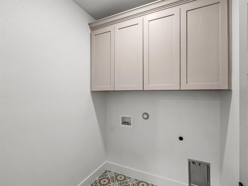 Clothes washing area with electric dryer hookup, washer hookup, cabinet space, baseboards, and gas dryer hookup