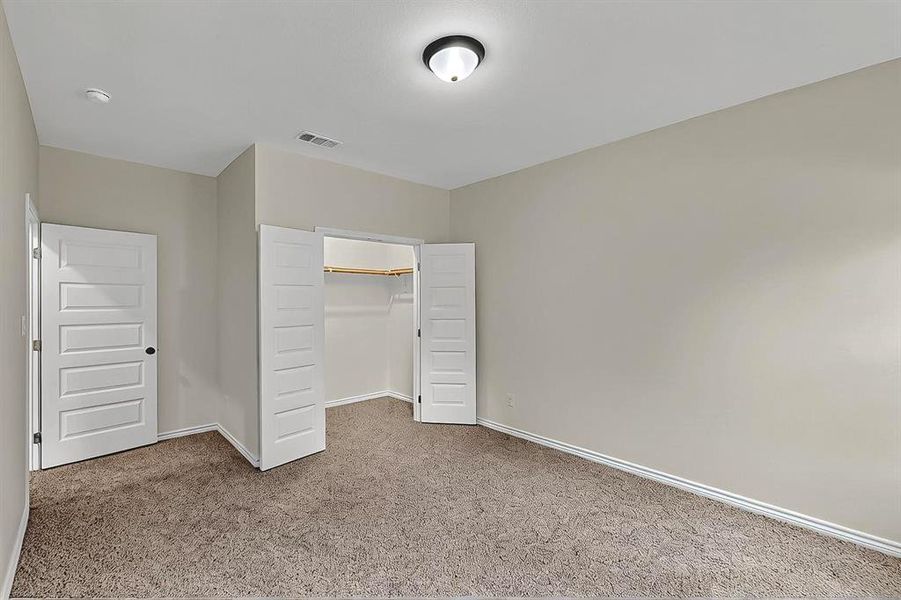 Unfurnished bedroom with visible vents, baseboards, carpet floors, and a closet Unfurnished bedroom with visible vents, baseboards, carpet floors, and a closet