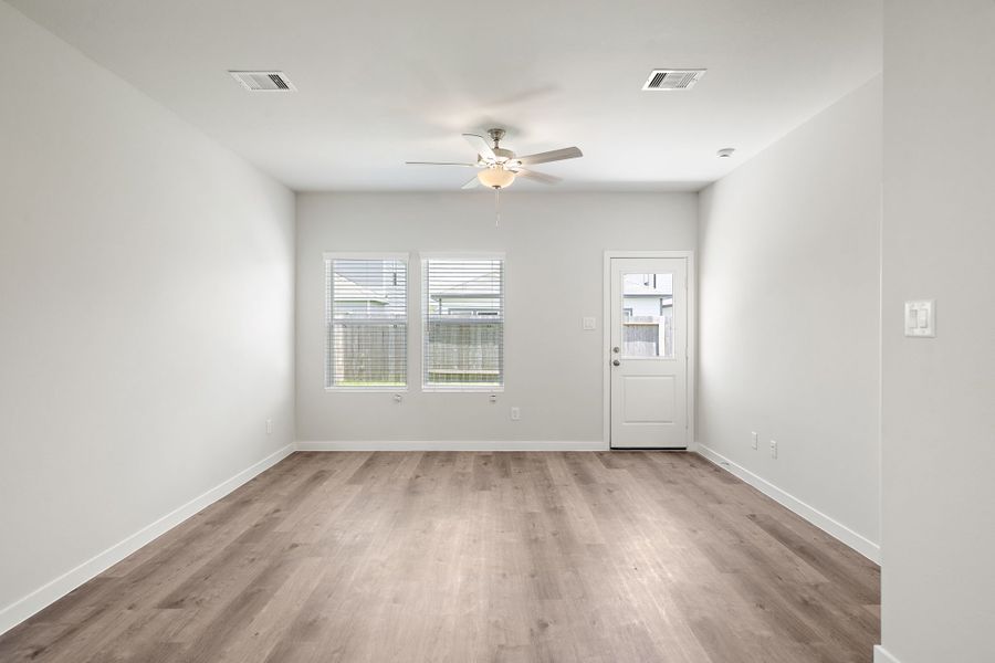 A room with a wood floor and a ceiling fan. A room with a wood floor and a ceiling fan.