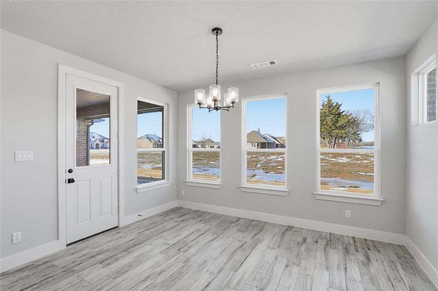 Unfurnished dining area with light wood-style flooring and a chandelier