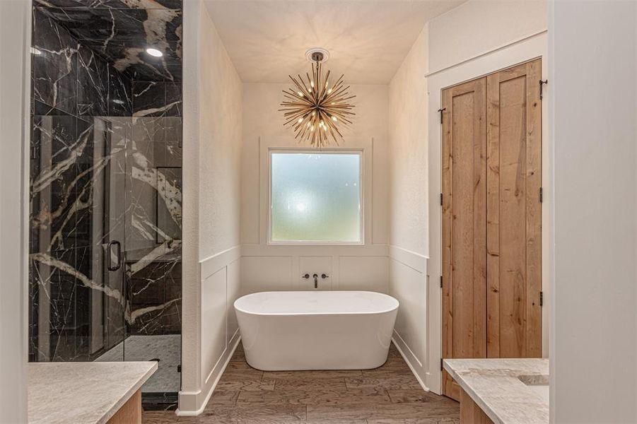 Bathroom with vanity, a marble finish shower, and a soaking tub