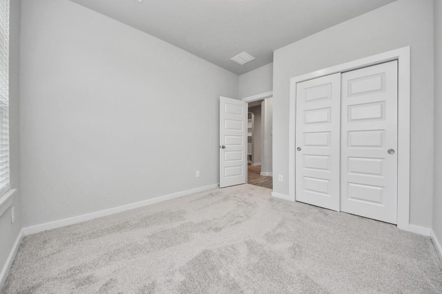 Generously sized secondary bedrooms featuring spacious closets, soft and inviting carpeting underfoot, large windows allowing plenty of natural light, and the added touch of privacy blinds for your personal retreat. Sample photo of completed home with similar floor plan. Actual colors and selections may vary.