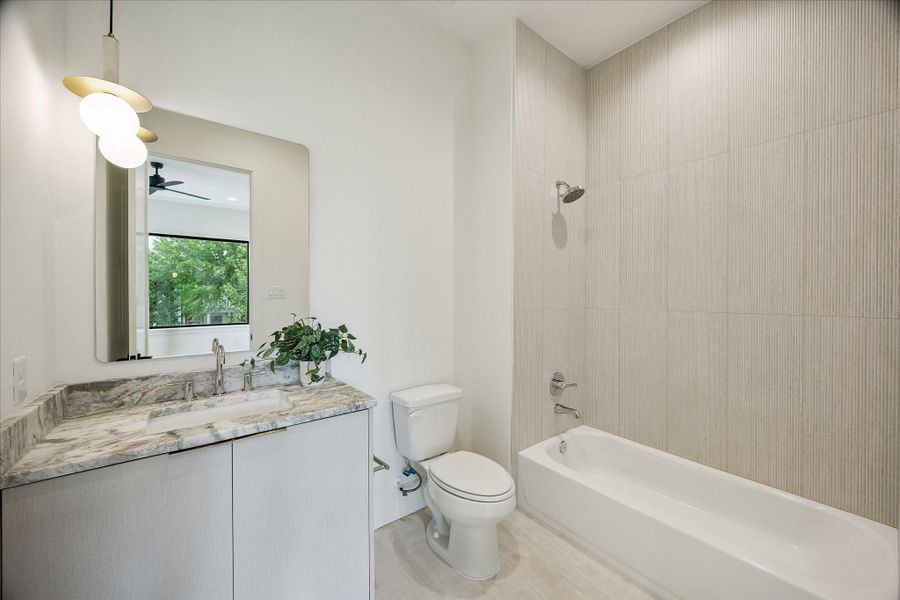 En-suite bath – features a shower/tub combo, designer pendant lighting, and Taj Mahal quartz countertop. En-suite bath – features a shower/tub combo, designer pendant lighting, and Taj Mahal quartz countertop.