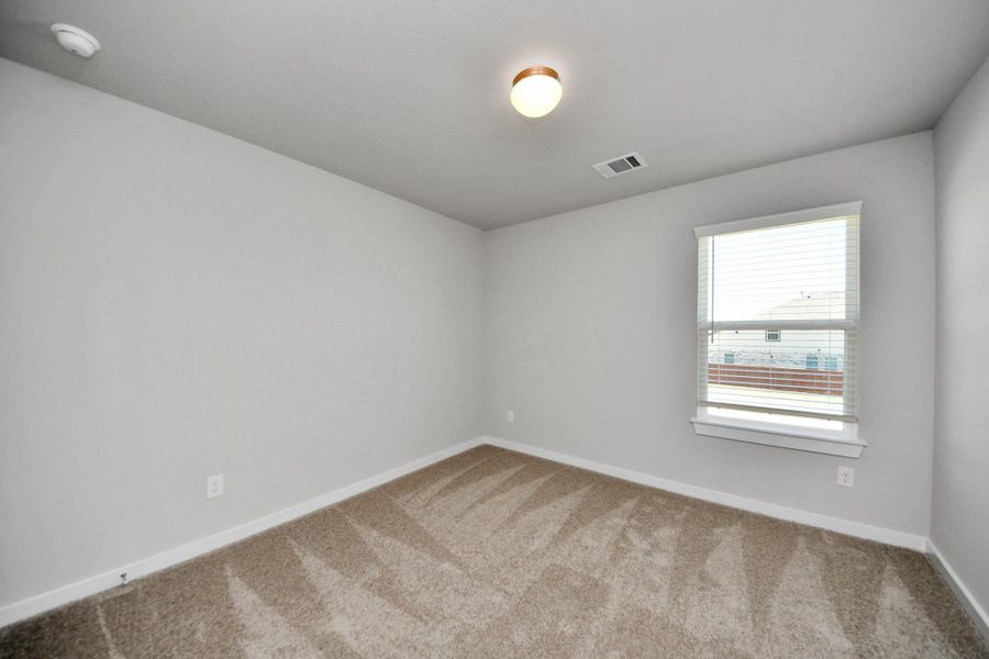 Secondary bedroom features plush carpeting, large windows that let in plenty of natural light, bright paint, and spacious closets. Sample photo of completed home with similar floor plan. Actual colors and selections may vary. Secondary bedroom features plush carpeting, large windows that let in plenty of natural light, bright paint, and spacious closets. Sample photo of completed home with similar floor plan. Actual colors and selections may vary.