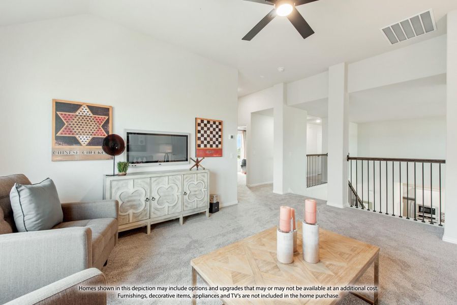 Upstairs living area with ceiling fan, TV console, sofa, and stair railing on carpeted floor Upstairs living area with ceiling fan, TV console, sofa, and stair railing on carpeted floor