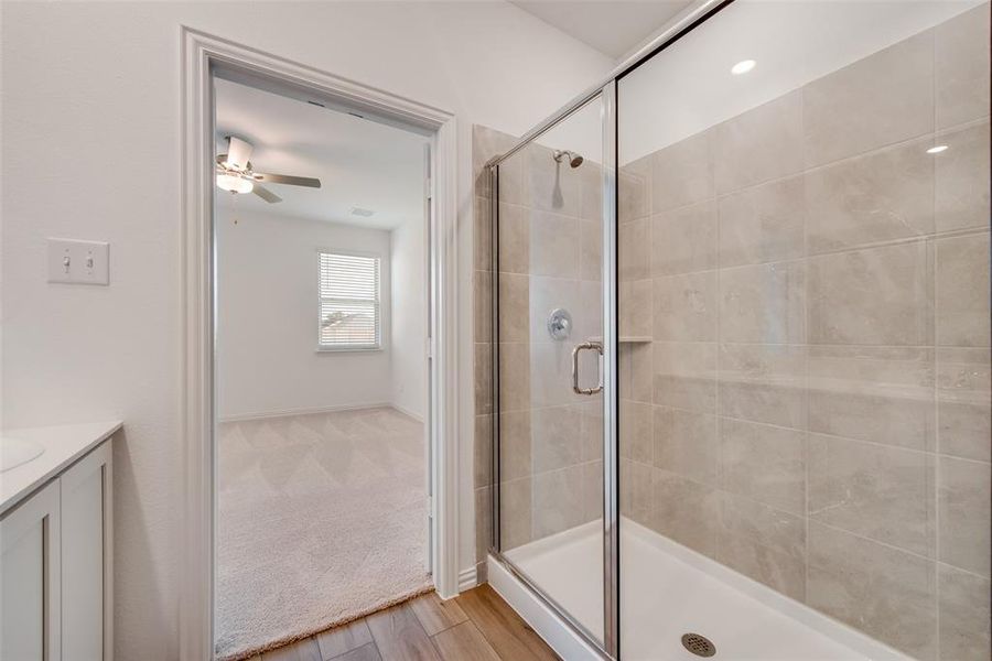 Bathroom featuring walk in shower, ceiling fan, hardwood / wood-style flooring, and vanity