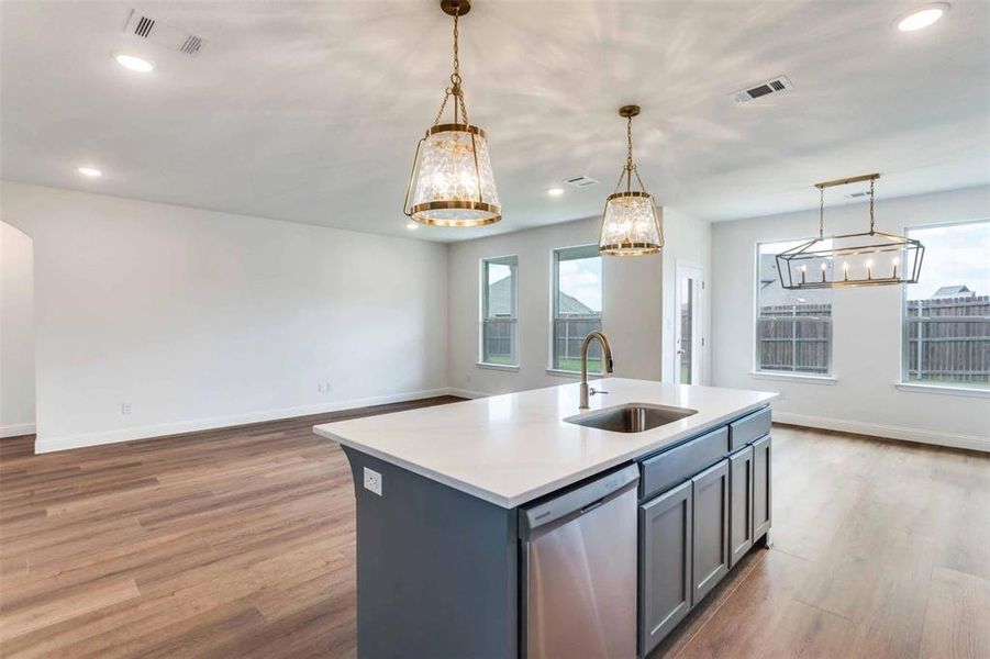 Kitchen with stainless steel dishwasher, a chandelier, light wood-style floors, open floor plan, and recessed lighting Kitchen with stainless steel dishwasher, a chandelier, light wood-style floors, open floor plan, and recessed lighting