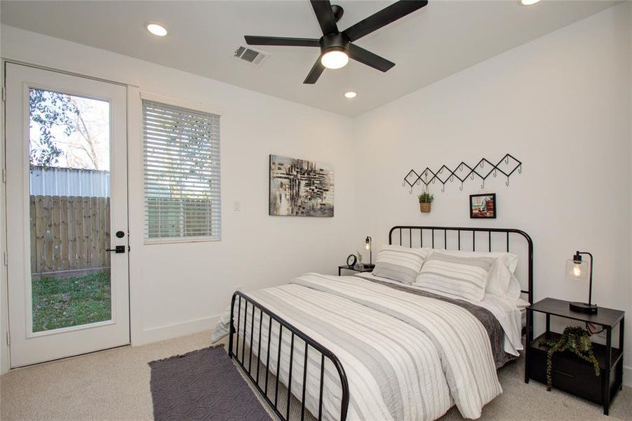 Secondary bedroom on the first floor with a private entrance through the backyard. Photos from another community by the same builder, FINISHES & FLOOR PLAN MAY VARY! Ceiling fans are not included!