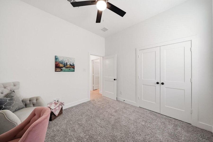 Double doors open to a generously sized closet, offering abundant storage, while a ceiling fan with integrated lighting, creating a comfortable and well-appointed retreat for family or guests.