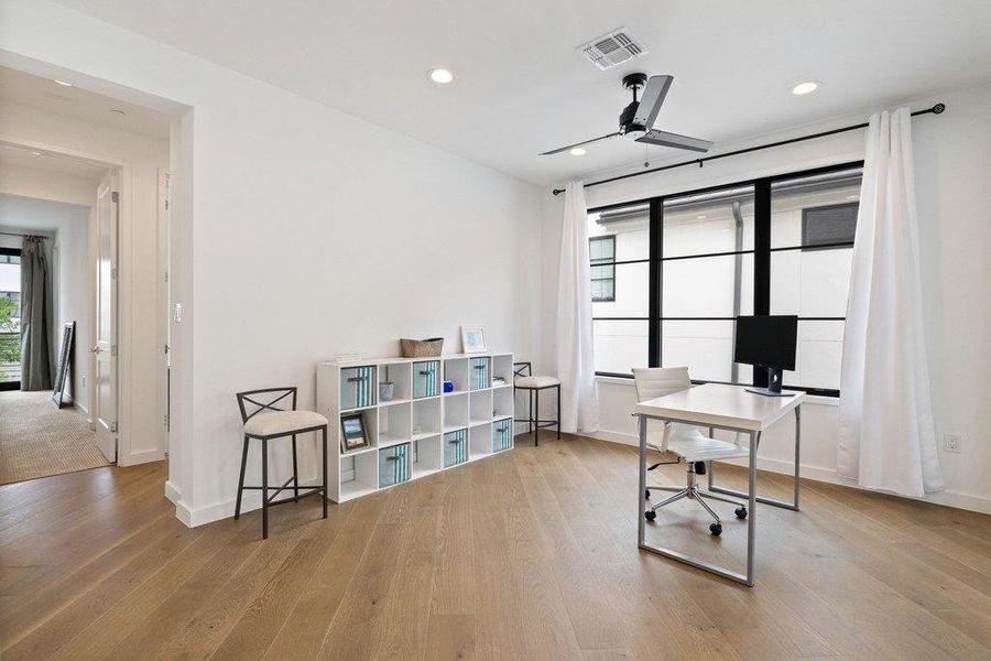 Bright interior space featuring wood-finish flooring, recessed lighting, and a contemporary ceiling fan
