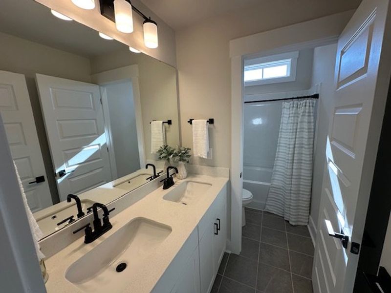 This sleek bathroom features a double vanity and a