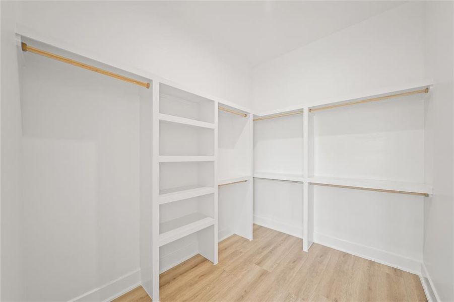 Spacious walk-in closet for the primary suite. Photos are from a similar unit in the development.