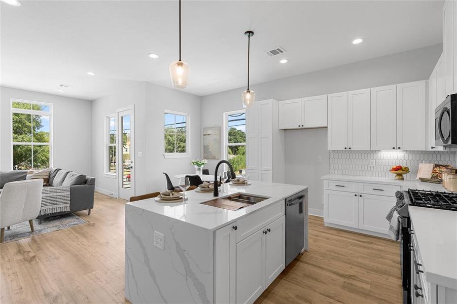 The kitchen showcases a full pantry and a classic farmhouse sink, expertly merging ample storage with timeless elegance for everyday functionality and style.