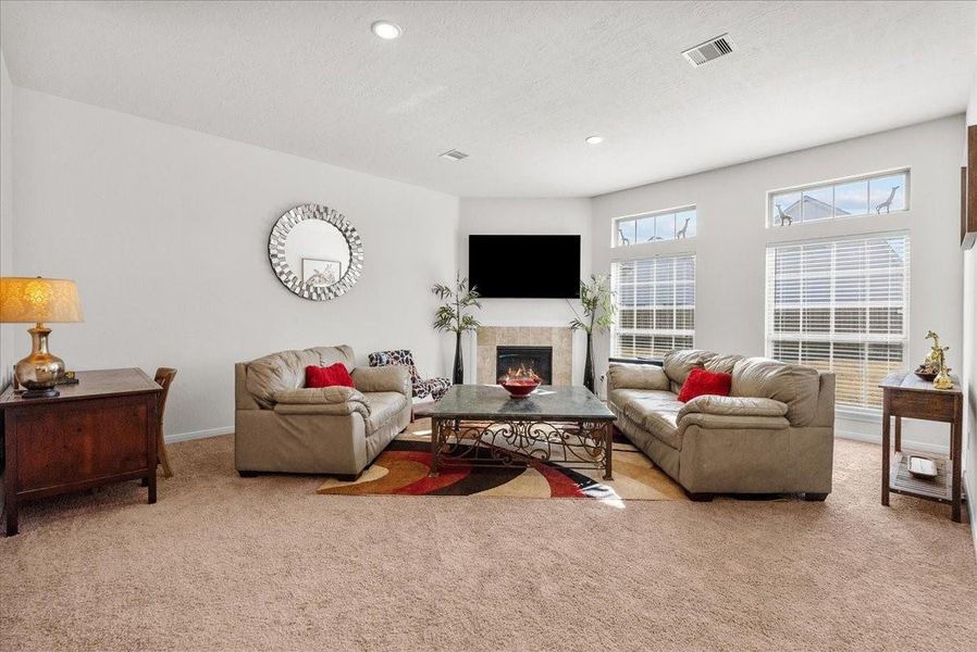 The living room features a cozy fireplace and is bathed in natural morning light through an abundance of windows The living room features a cozy fireplace and is bathed in natural morning light through an abundance of windows