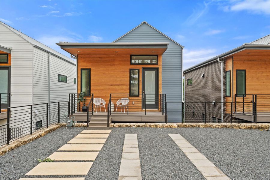 A striking modern facade features natural wood siding, dark trim, and a welcoming front porch. A striking modern facade features natural wood siding, dark trim, and a welcoming front porch.