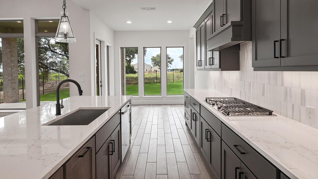 Kitchen with stainless steel appliances, decorative backsplash, light stone counters, hanging light fixtures, and recessed lighting Kitchen with stainless steel appliances, decorative backsplash, light stone counters, hanging light fixtures, and recessed lighting
