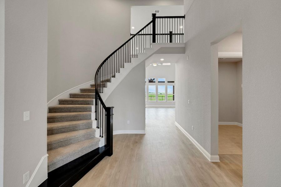 Staircase with a towering ceiling and wood finished floors Staircase with a towering ceiling and wood finished floors