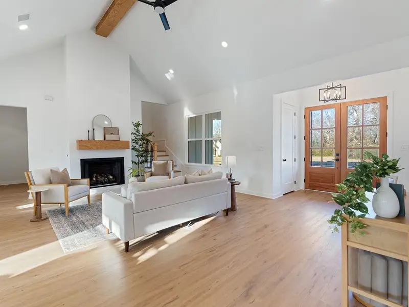 Living room with ceiling fan, french doors, light wood-style flooring, recessed lighting, and a fireplace