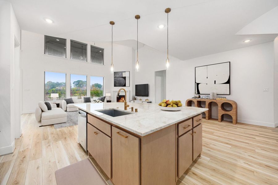 An open kitchen design features a spacious island, pendant lighting, and seamless connection to the living area.