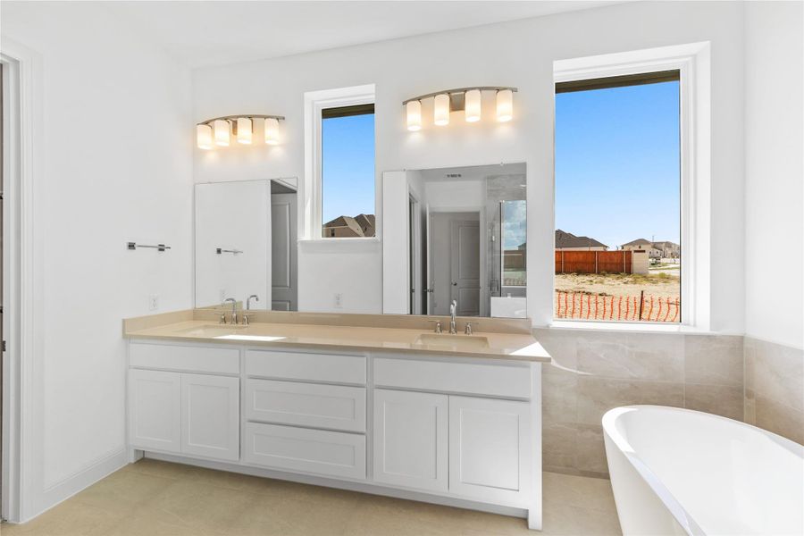 Full bath featuring double vanity and a soaking tub