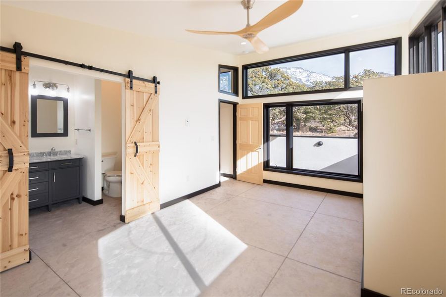 large primary with double barn doors to bathroom