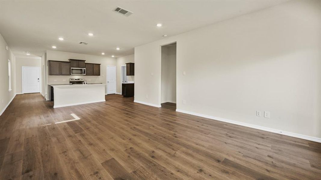 Open-concept living area featuring wood-finish flooring, recessed lighting, and light-toned walls