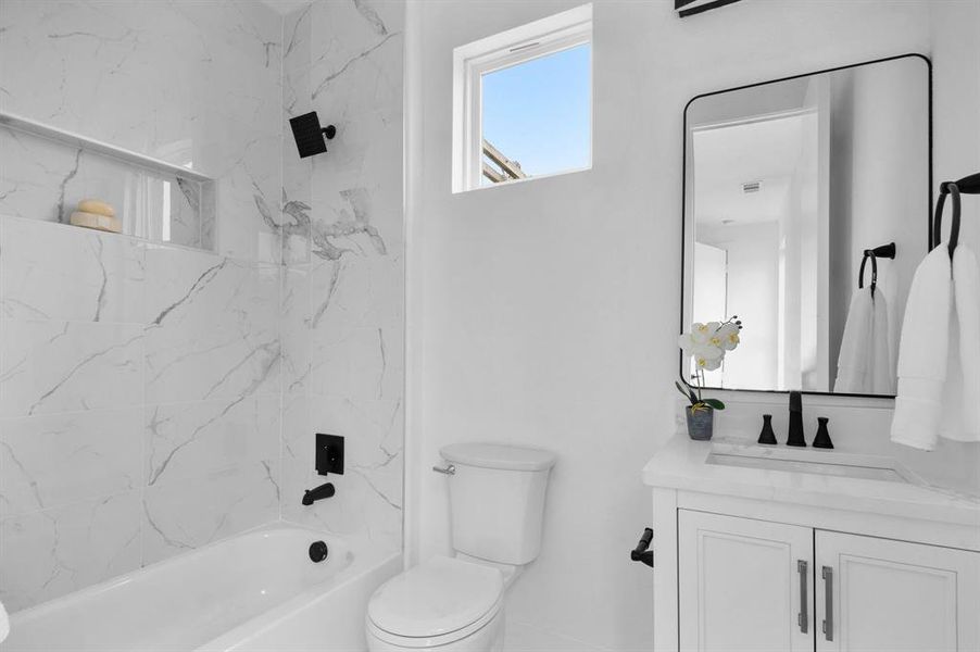 Full bathroom featuring vanity, toilet, and tiled shower / bath