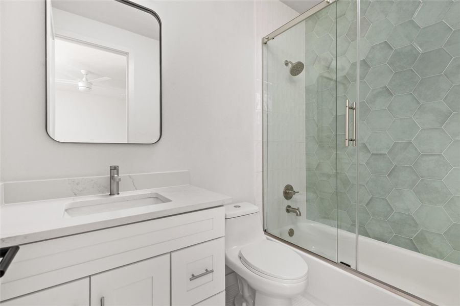 Full bathroom with combined bath / shower with glass door and vanity