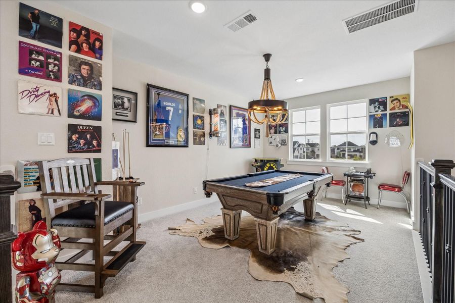 Upstairs, the spacious game room welcomes you with plenty of room for a pool table or additional lounge seating, all enhanced by large windows that bring in natural light.