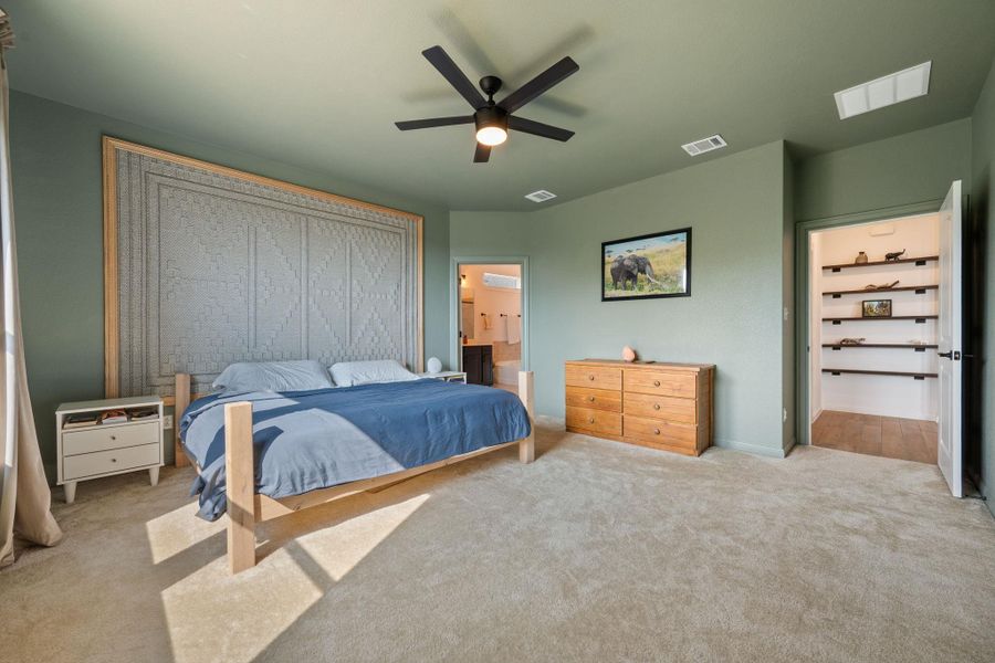 Carpeted bedroom with ceiling fan and ensuite bath Carpeted bedroom with ceiling fan and ensuite bath