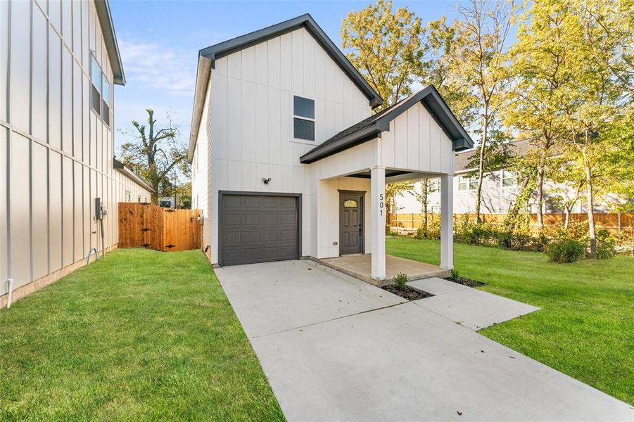 Modern farmhouse style home featuring board and batten siding, a gate, concrete driveway, and an attached garage Modern farmhouse style home featuring board and batten siding, a gate, concrete driveway, and an attached garage