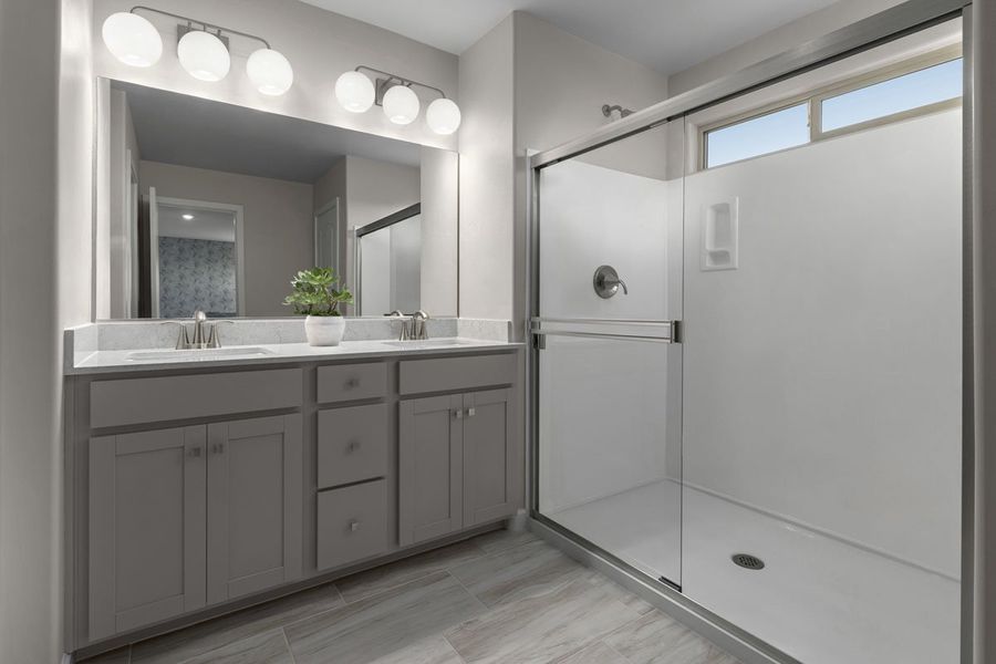 Upgraded walk-in shower with cultured marble surround at primary bath