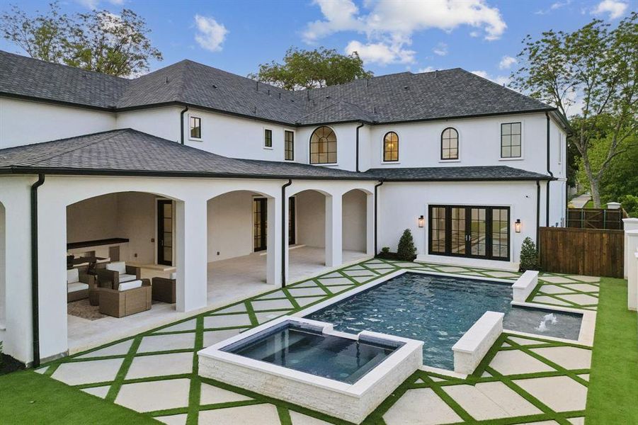 Rear view of property featuring a patio, an outdoor hangout area, and a pool with hot tub