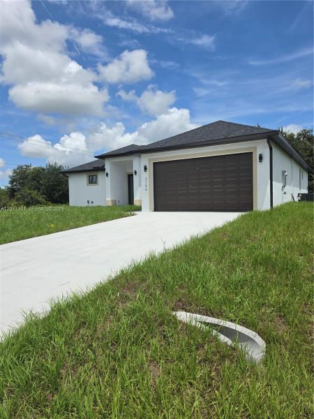 Front exterior of a new home in , Lehigh Acres, FL, highlighting curb appeal (Image 17).