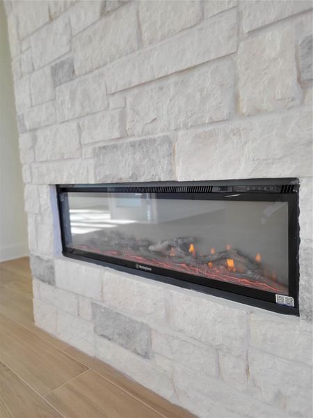This photo showcases a modern fireplace set within a white stone wall, creating a cozy and stylish focal point in the room. This photo showcases a modern fireplace set within a white stone wall, creating a cozy and stylish focal point in the room.