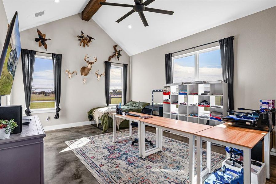Home office featuring concrete flooring, healthy amount of natural light, beam ceiling, high vaulted ceiling, and ceiling fan Home office featuring concrete flooring, healthy amount of natural light, beam ceiling, high vaulted ceiling, and ceiling fan