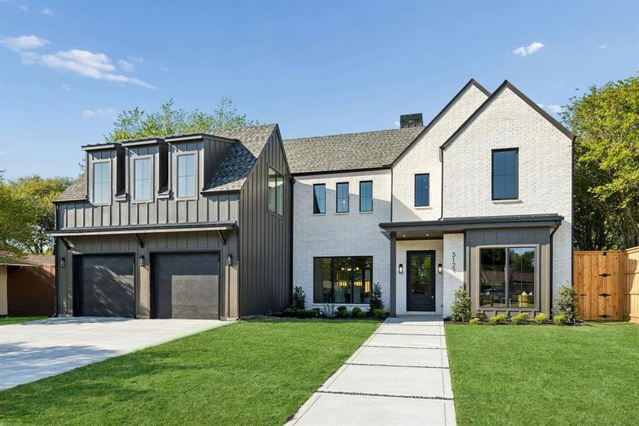 Modern farmhouse style home with board and batten siding, an attached garage, brick siding, and concrete driveway